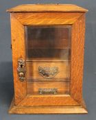 Edwardian oak smokers cabinet, with bevelled glass door and two internal drawers