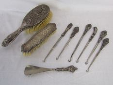 White metal hairbrush with Kali design, silver backed clothes brush, silver handled boot hooks and