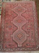Handmade Turkish wool rug on red ground 147cm x 102cm