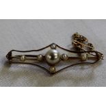 Gold bar brooch set with seed pearls and central faux pearl, appears to be marked 15, 3.01g