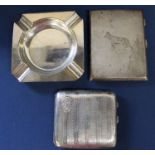 Silver engine turned cigarette case with engraved Alsatian decoration, one other cigarette case &