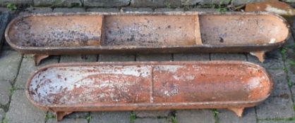 Two cast iron pig troughs