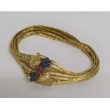 Continental gold testing as 18ct seven textured strand bracelet with floral clasp set with sapphires
