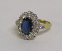 18ct gold sapphire and diamond cluster ring, the central claw set oval sapphire approximately 1.30ct