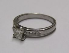 Platinum (tested as mark worn) ring set with square cut diamond solitaire .50ct and 5 diamonds to