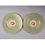 A pair of Royal Worcester cabinet plates with celadon glazed and gilt borders and central fruit