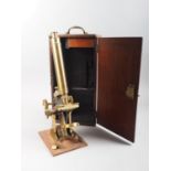 A 19th century brass monocular microscope with two lenses, in fitted mahogany case, 15 1/2" high