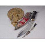 A Chinese brass door knocker, formed as a mask, 6 1/2" wide x 9 1/4" high, and a kukri, in white