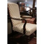 A late 19th century rosewood showframe open armchair, upholstered in a figured brocade, on turned