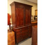 An early 19th century figured mahogany linen press, the upper section enclosed two doors over two