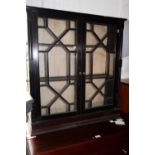 An ebonised bookcase/display cabinet enclosed glazed panel doors with flanking cluster columns,