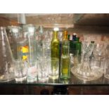 An assortment of glassware, including a pair of candlesticks, drinking glasses, poison bottles and