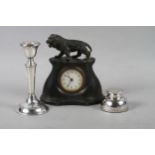 A pewter cased mantel clock with a lion surmount, a silver inkwell and a filled silver candlestick