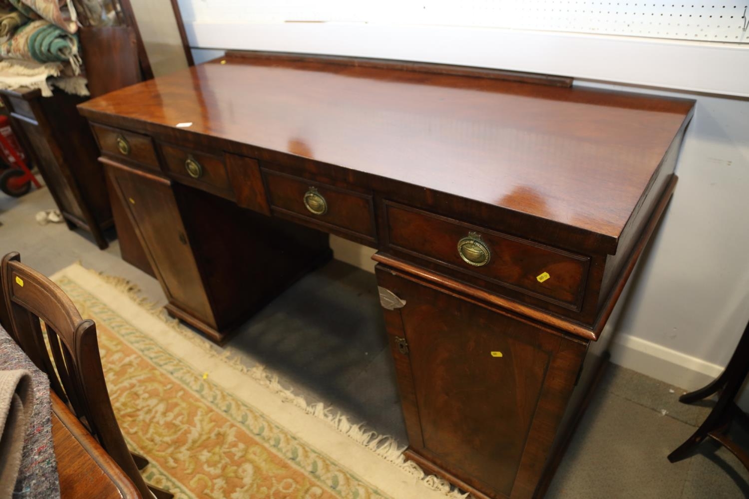 A William IV figured mahogany double pedestal sideboard, fitted three drawers with ring handles over