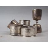 Five silver napkin rings, various, a brushed steel napkin ring and a spirit measure