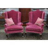 A pair of wing armchairs of Georgian design with scroll arms, on cabriole supports (one for