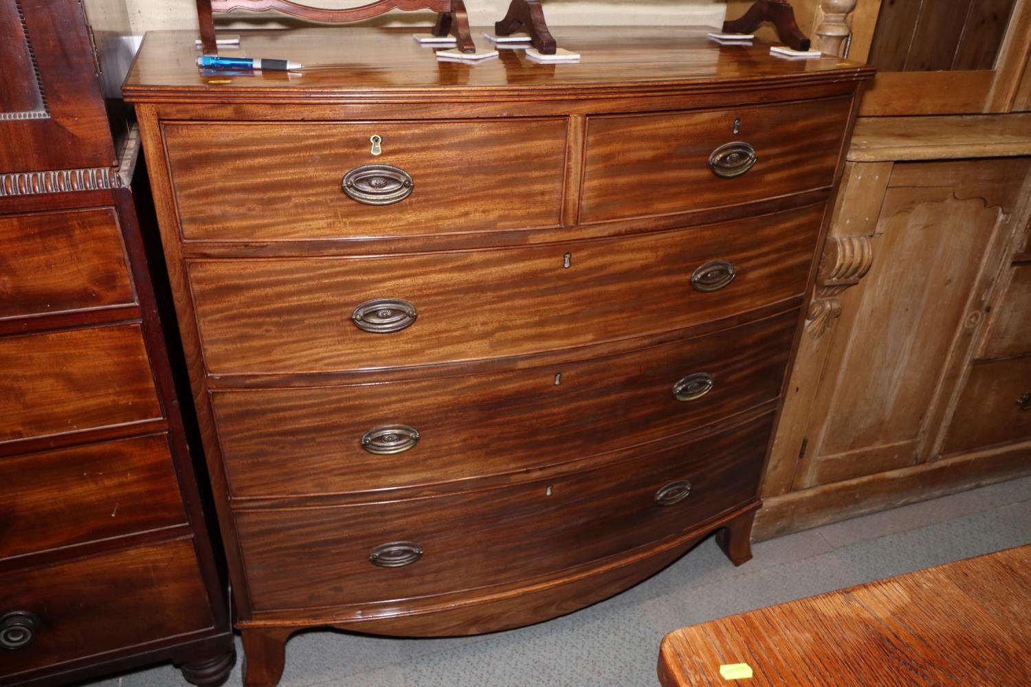 A 19th century mahogany bowfront chest of two short and three long graduated drawers with oval brass