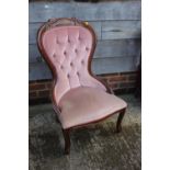 A carved walnut showframe nursing chair, button upholstered in a pink velour, on cabriole supports