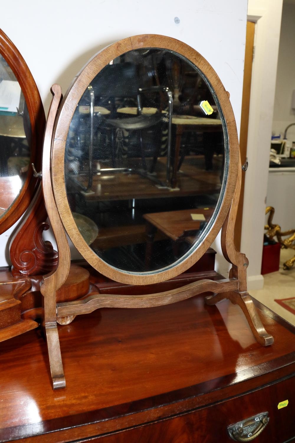 A walnut oval swing frame toilet mirror, on splay supports, 15 1/2" wide x 20 1/2" high overall
