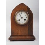 An early 20th century oak arch top mantel clock with line inlay and eight-day striking movement with