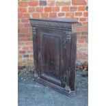 An oak corner hanging cupboard of 17th century design with flanking columns and panel door, 27" wide