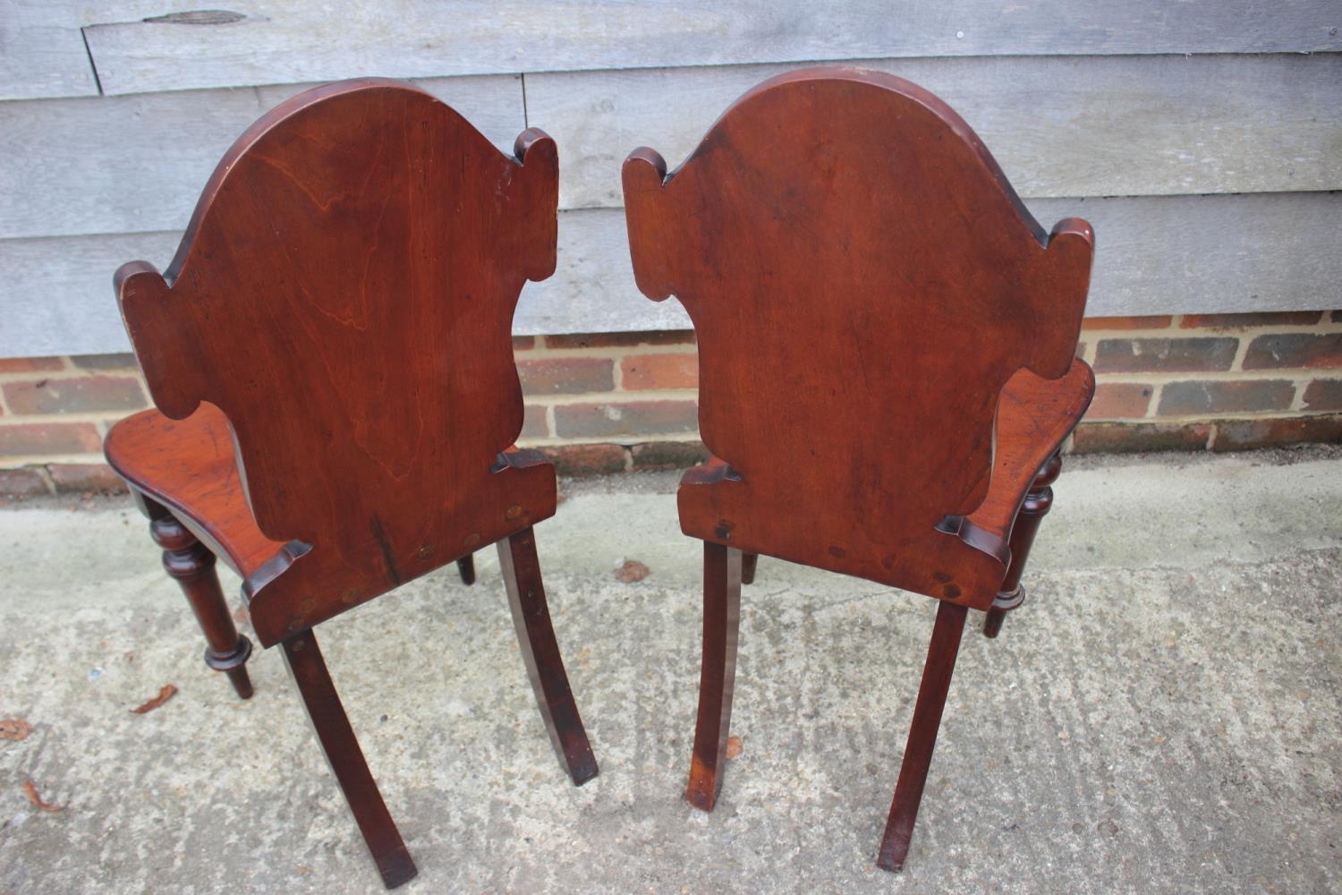 A pair of 19th century carved mahogany hall chairs with shaped panel backs, on turned supports - Image 5 of 6