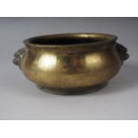 A Chinese brass coloured bronze censor with handles and four character stamp mark to base, 5" dia