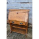 An oak fall front desk with fitted interior over one long drawer and open shelf, 26" wide x 12" deep