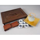 A Japanese carved hardwood tea tray, a scrolled hardwood stand, 8" wide, four sake cups and a