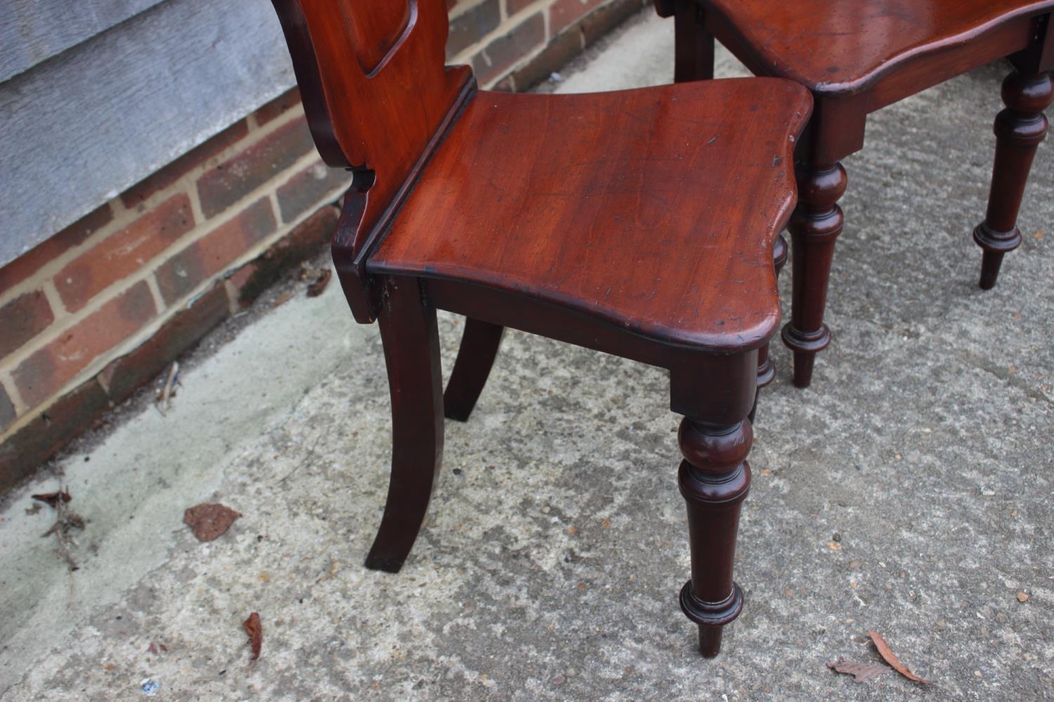 A pair of 19th century carved mahogany hall chairs with shaped panel backs, on turned supports - Image 2 of 6