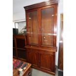 A late 19th century walnut bookcase, the glazed upper section enclosed two doors over two drawers