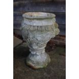 A cast stone urn with relief decoration of roses, 26" high