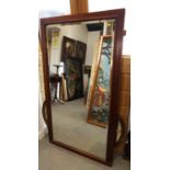 A walnut framed wall mirror with bevelled edge, plate 55" x 28"