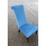 A late 19th century rosewood framed prie-dieu, upholstered in a blue fabric, on turned and