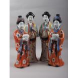 A pair of Chinese porcelain figures of women in orange robes holding jars, 14" high, a similar pair,