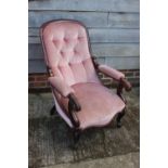 A carved mahogany scroll arm showframe chair, button upholstered in a pink velour, on cabriole