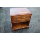 A yew and banded low bedside chest, fitted slide over two short and one long drawer and recess, on