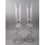 A pair of Baccarat glass candlesticks with frosted dolphin stems, cut glass drops and engraved glass
