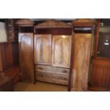 An early 19th century figured mahogany double sentry box wardrobe, the centre section fitted