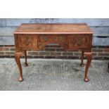 A figured walnut and banded desk, fitted one shallow and two deep drawers, on shell carved