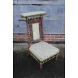 A late 19th century carved oak prie-dieu chair of Restoration design with Jacquard seat and back