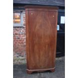 A 1930s figured walnut corner hall wardrobe enclosed oval panelled door, on bracket feet, 37" wide x