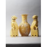A Chinese porcelain yellow ground white enamel decorated vase, 9" high, and a pair of Dogs of Fo, 8"