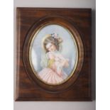A portrait miniature on ivory of a girl with doves, 4 1/2" x 3 3/4", in walnut frame