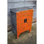 A Chinese red lacquered butterfly decorated cupboard, on stile supports, 22" wide x 14 1/2" deep x