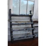 A carved and ebonised four-tier open wall shelf of 17th century design, 22" wide x 4 1/2" deep x 28"