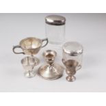 Two silver mounted dressing toilet jars, two miniature silver trophy cups, a silver egg cup and a