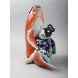 A Chinese porcelain vase formed as a figure holding a carp, 11" high