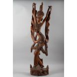 A Balinese carved hardwood figure of a dancer, 39" high