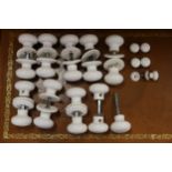 A collection of approximately twelve pairs of white porcelain door knobs